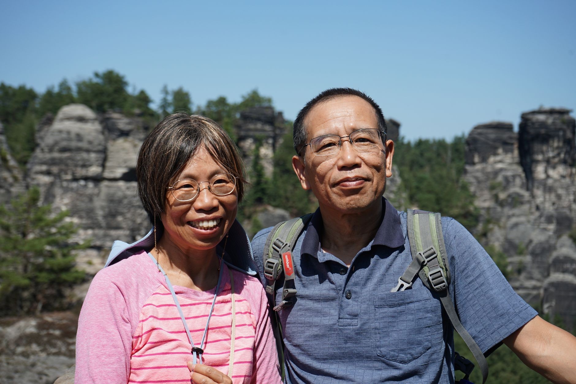 Hikers moving through sandstone-rock landscape associated with Bohemian Switzerland.