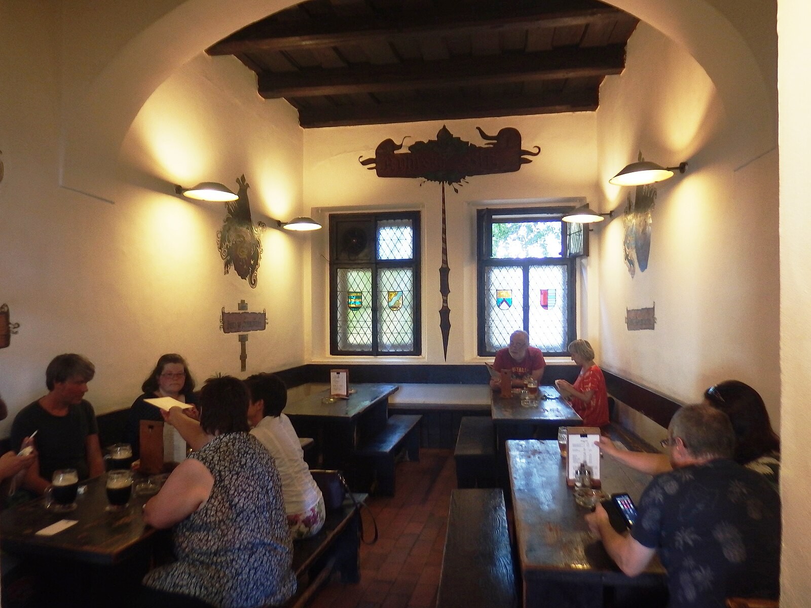 Interior of the traditional Prague pub U Černého vola with tables, benches and lived-in hospoda atmosphere.