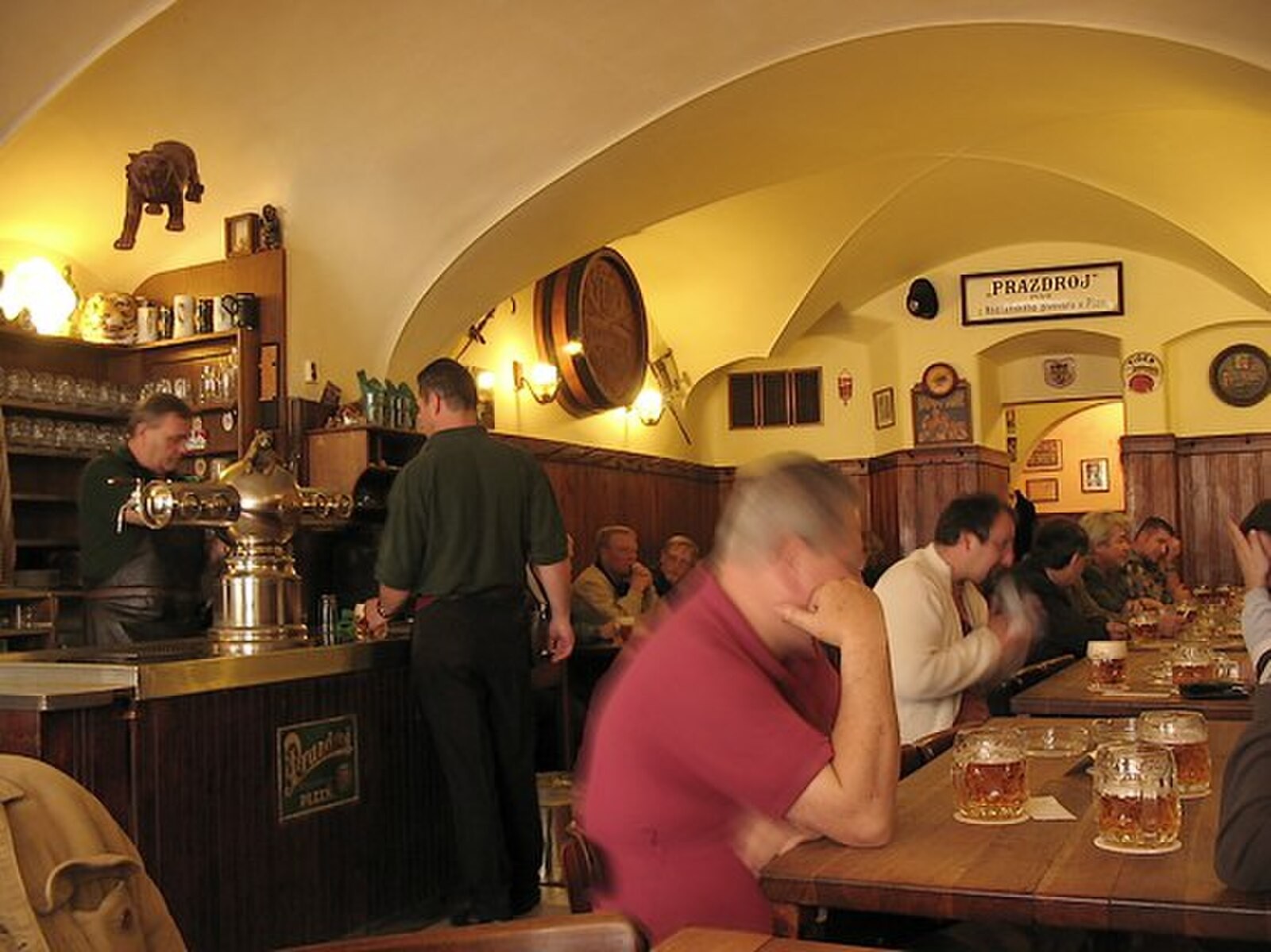Interior of Prague’s U Zlatého tygra pub, with classic communal tables and dense traditional atmosphere.