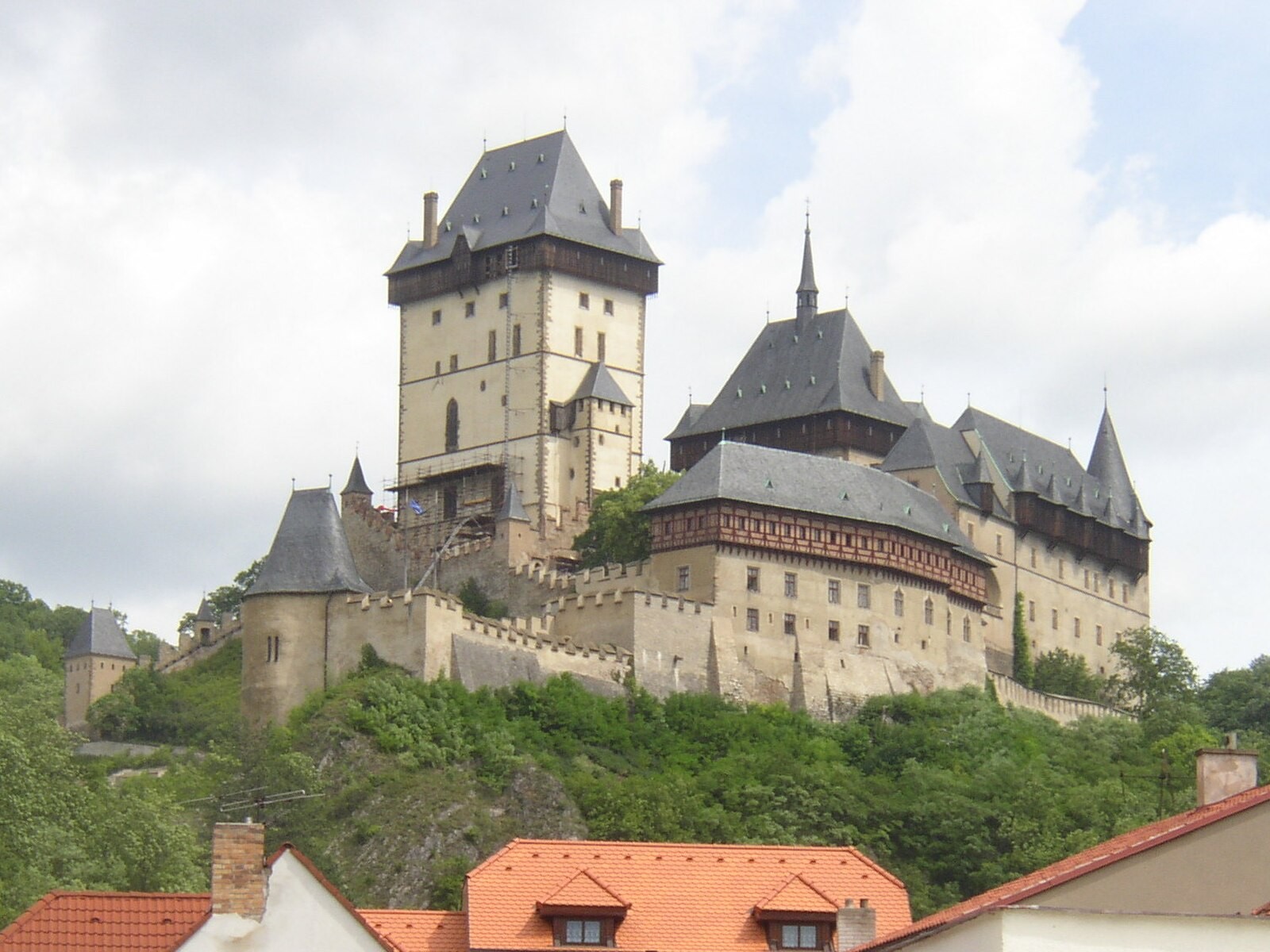 Karlštejn Castle seen prominently on its wooded hill.