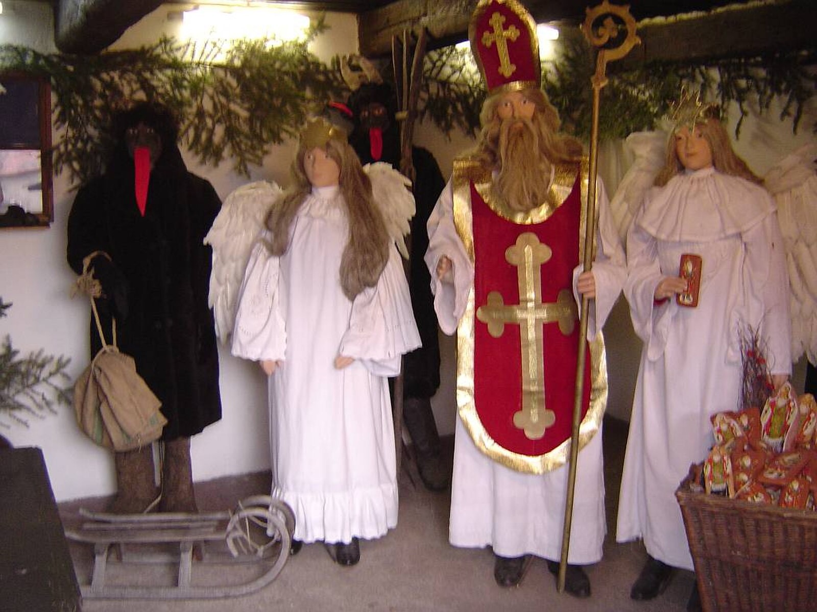St Nicholas, angel and devil figures in a Czech display context, avoiding identifiable modern participants.