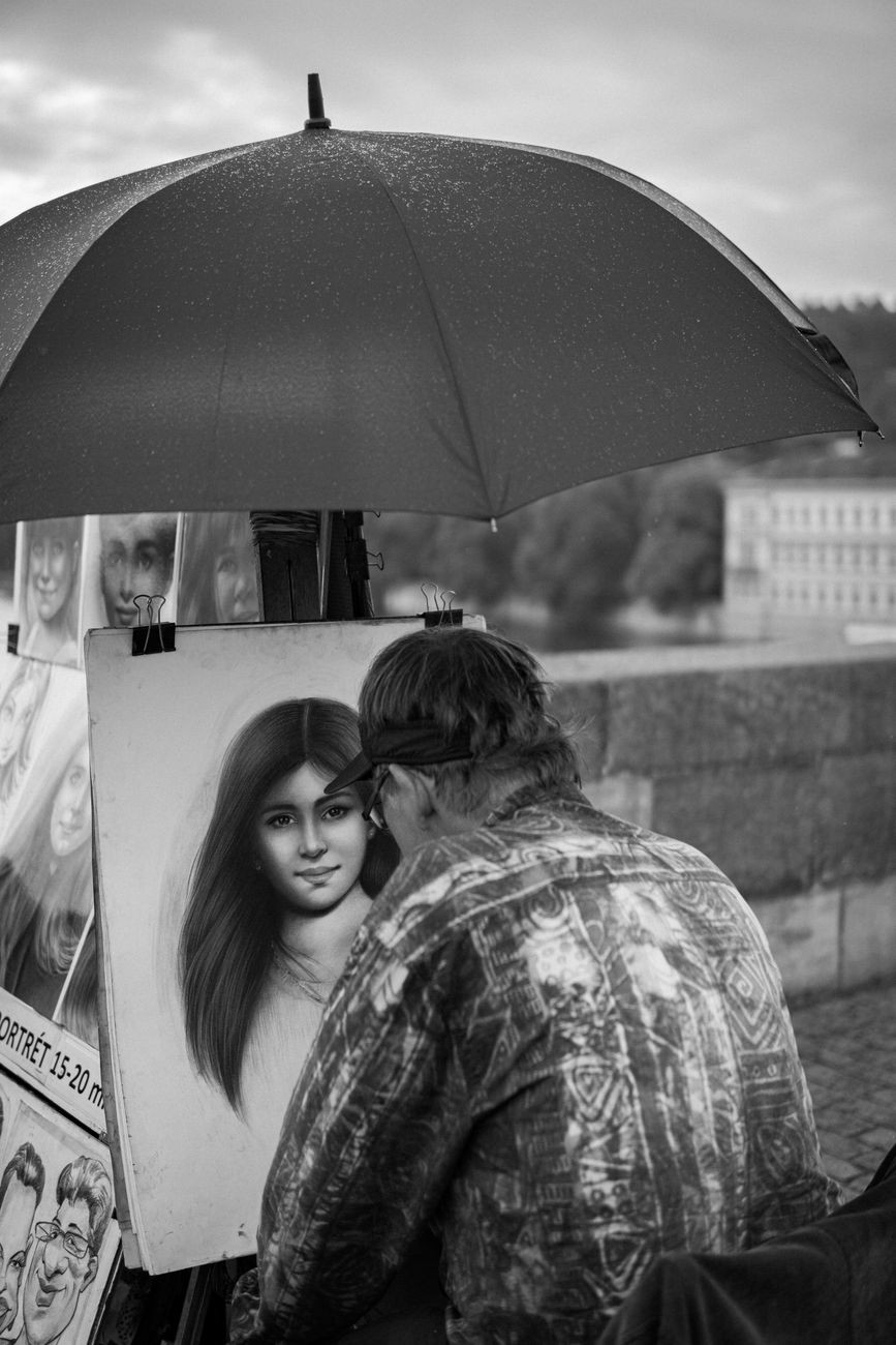 Prague street scene with rain/umbrella context.
