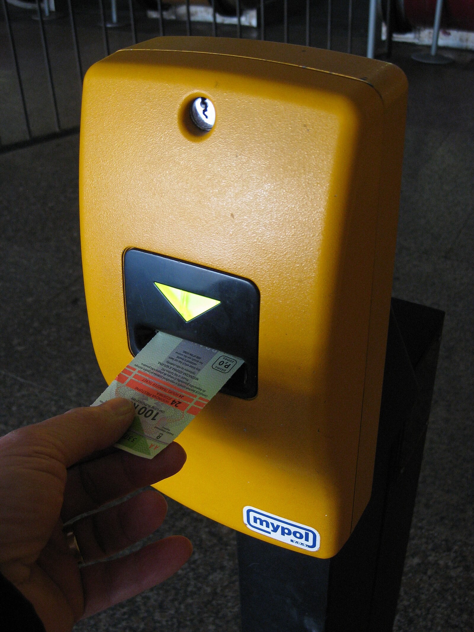 Hand validating a paper Prague public-transport ticket in a stamping machine.
