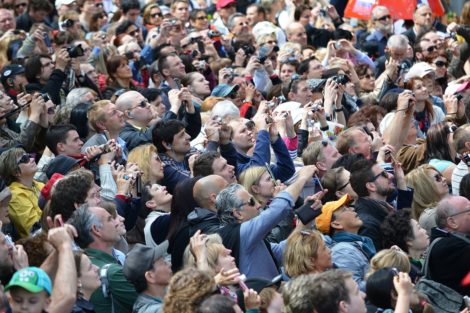 Dense tourist crowd photographing the Prague Astronomical Clock.