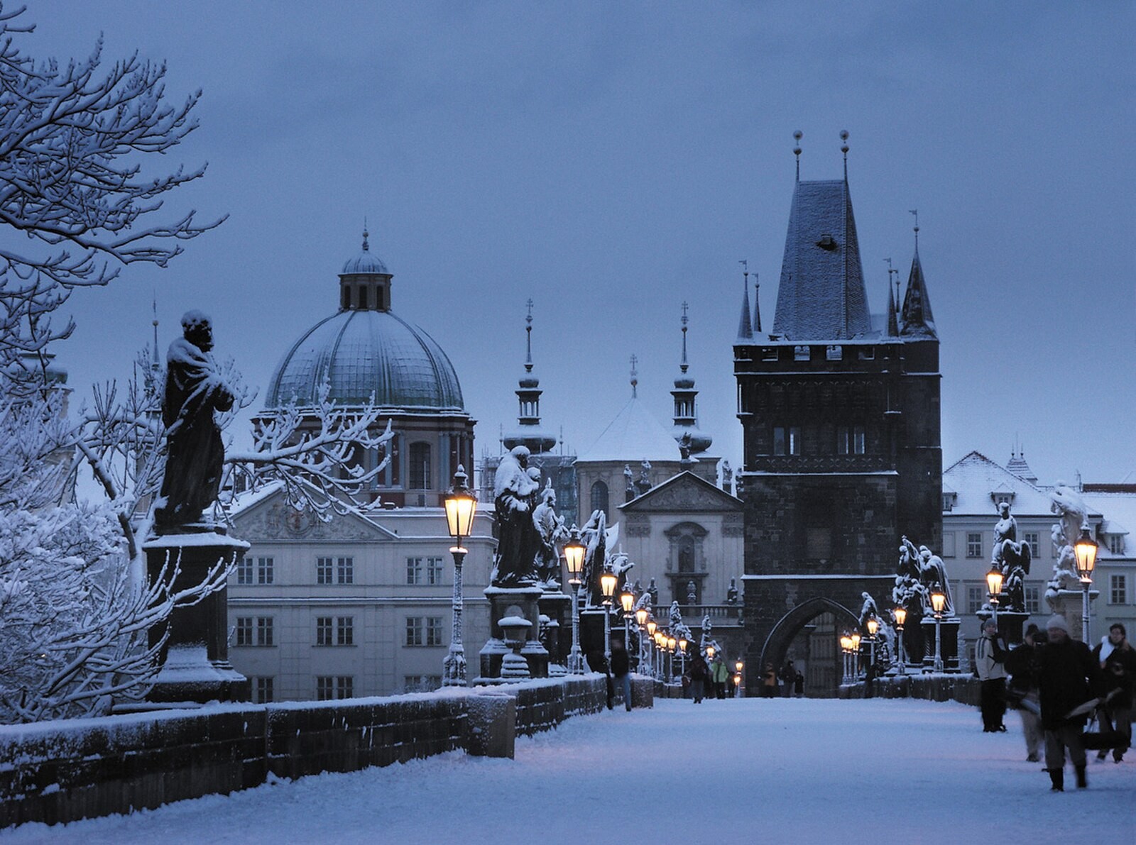 Charles Bridge and surrounding Prague architecture covered in winter snow.