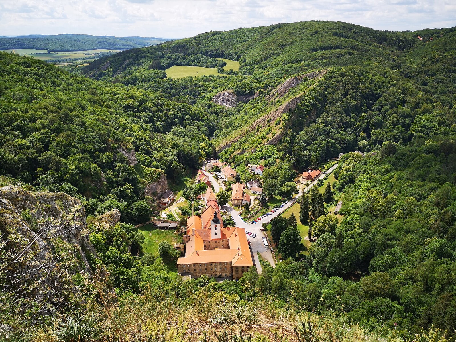 High viewpoint over the monastery/village from the limestone cliff, showing the site’s dramatic topography.