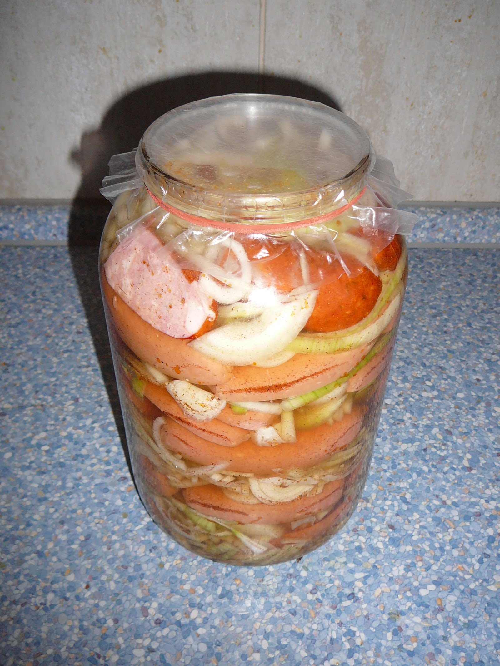 Jar/plated view of multiple marinated utopenci, showing the pickling format.