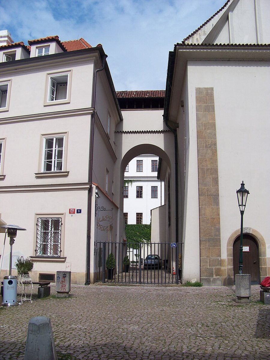 Portrait view into the courtyard side of Bethlehem Chapel and adjacent gate.