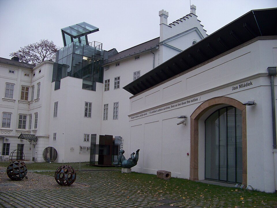 Clear wide courtyard façade with 'SOVOVY MLÝNY' visibly written on the building.
