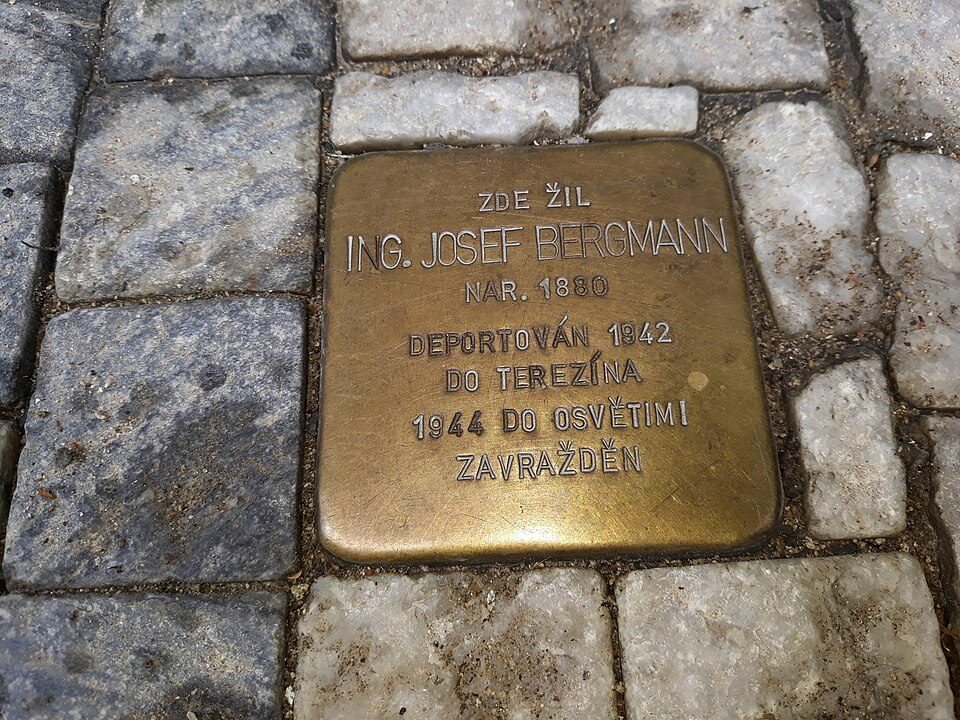 Single brass Stolperstein filling much of the frame, set in stone paving.
