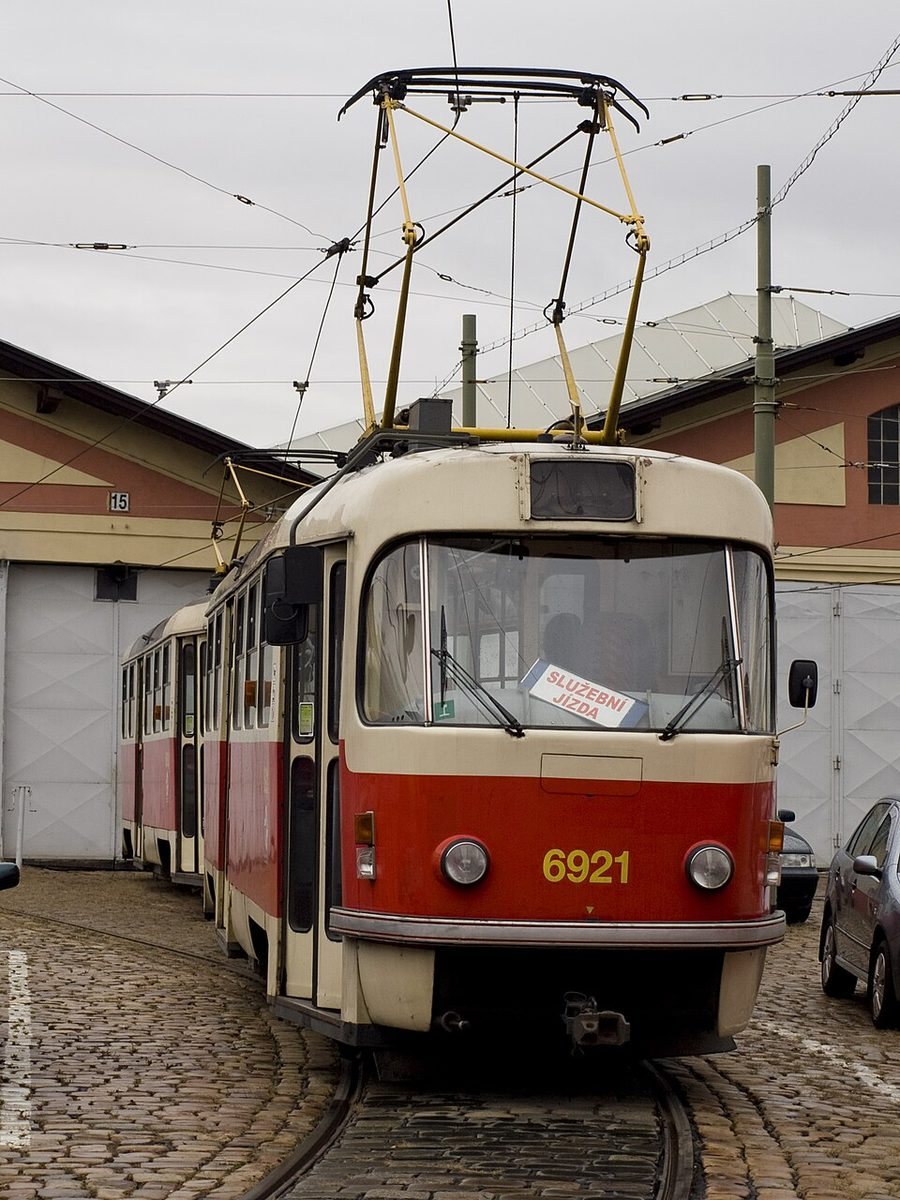 Historic tram posed on depot tracks directly in front of the Střešovice-style depot sheds.