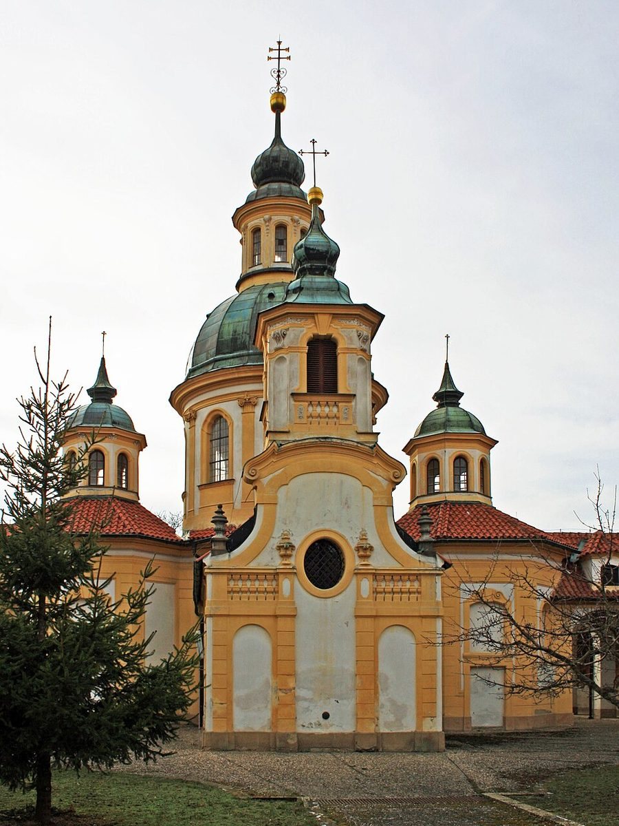 Portrait of the yellow-and-white Baroque pilgrimage church/complex with multiple domes.