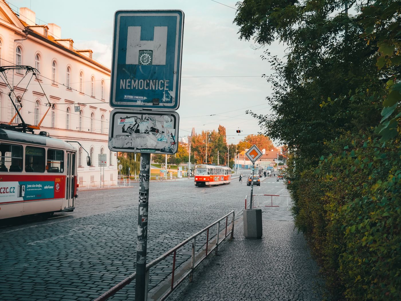 Historic-style Prague trams and cobbled transport corridor are visibly shown.