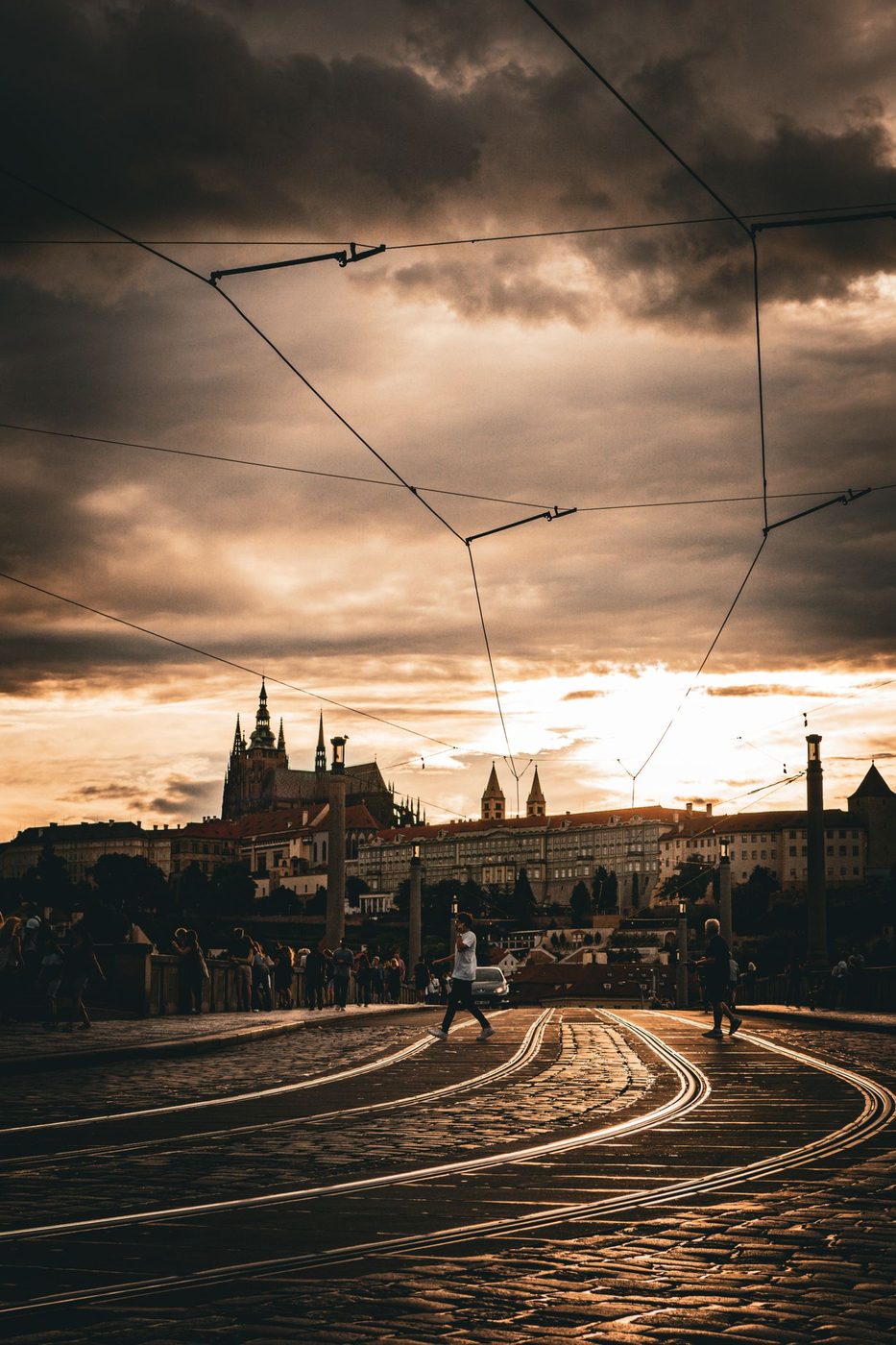 Prague street rising toward castle context is visibly shown.