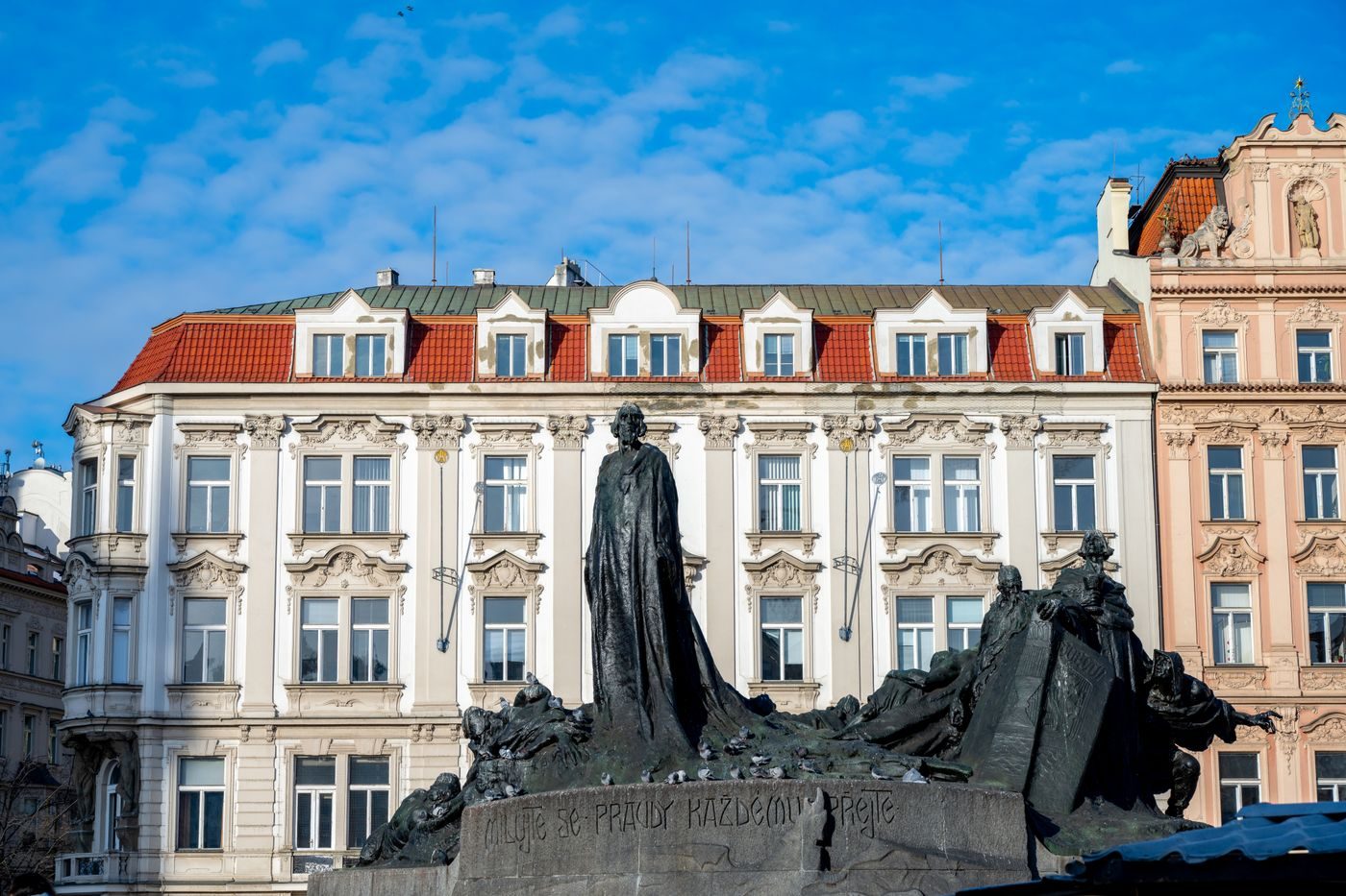 Exact Old Town Square monument and surrounding architecture are visibly shown.