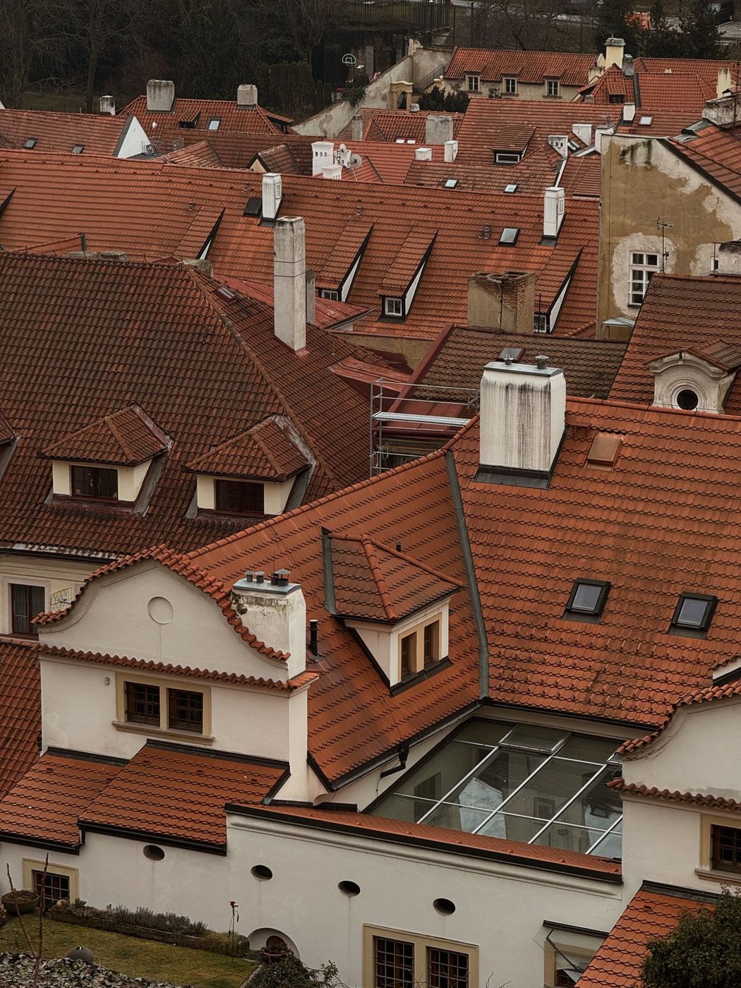 Elevated Prague roofscape is visibly shown from a high historic-city viewpoint.