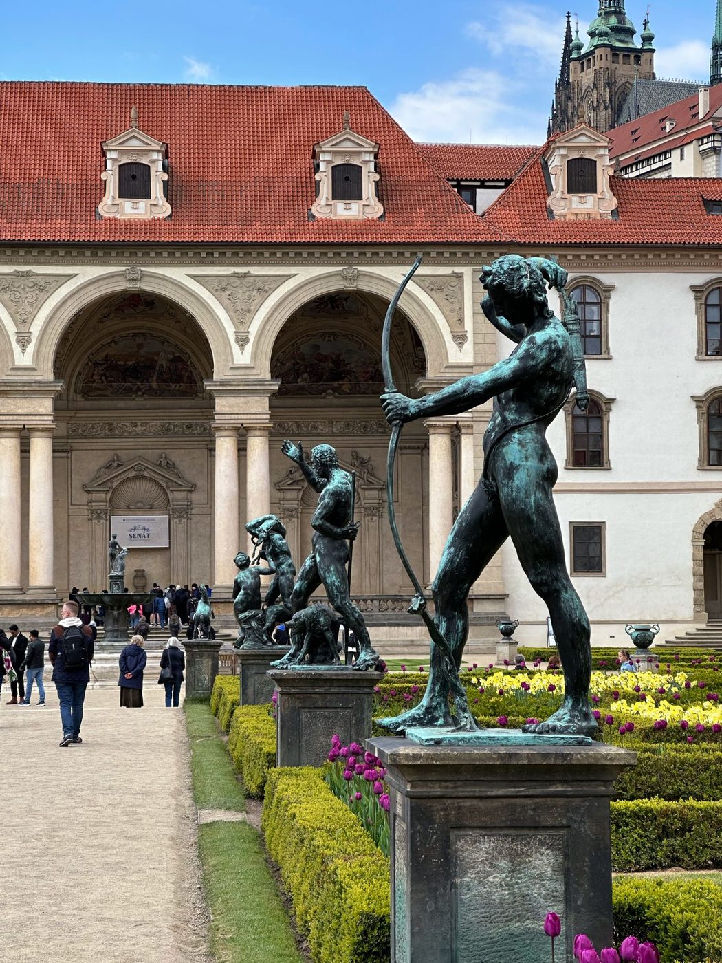 Historic statues, garden paths and Prague courtyard architecture are visibly identified as Wallenstein Garden.